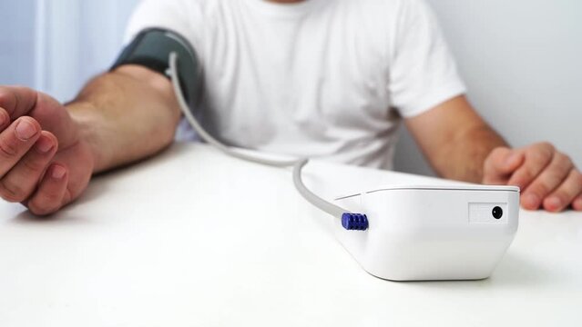 the girl measures blood pressure with a tonometer