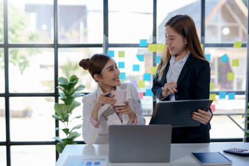 Obraz premium Two beautiful young Asian businesswoman in the conversation, exchanging ideas presentation analyze plan marketing and investment.