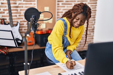 African american woman musician composing song at music studio