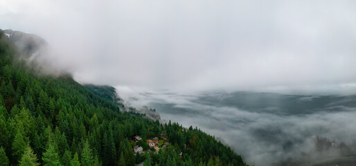 Howe Sound covered in Clouds and Fog during morning. Aerial Panorama