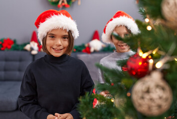 Adorable boys smiling confident decorating christmas tree at home