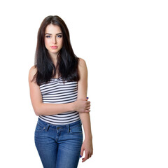 Fototapeta premium Studio portrait of young charming woman in blue jeans with long dark hair, over white background.