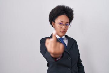 Beautiful african woman with curly hair wearing business jacket and glasses showing middle finger,...