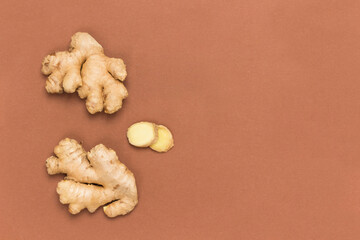 Raw ginger root and dry ginger on brown