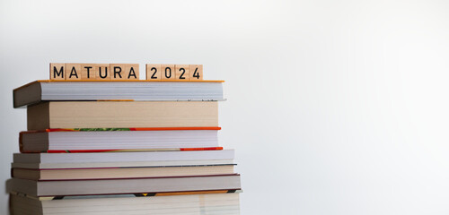 Matura 2024 - napis z drewnianych kostek, ułożony na książkach, maj, egzamin maturalny