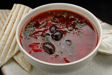 Red borscht with beans, sour cream and pita bread