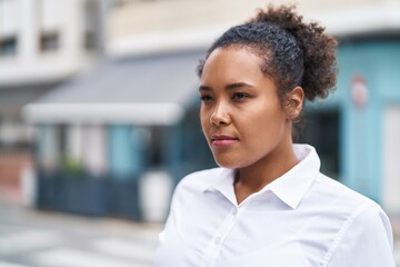 African american woman looking to the side with serious expression at street