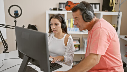 Male and female musicians vibing to their newly crafted melody in the music studio, deep in...