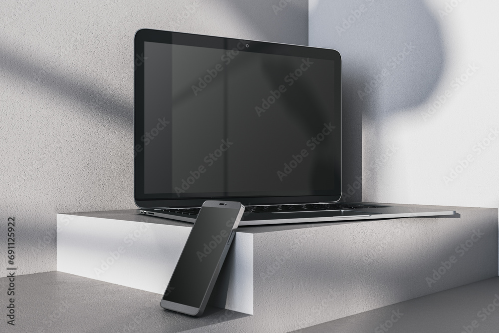 Poster close up of empty laptop and smartphone on gray desk. concrete wall background and pedestal or podiu