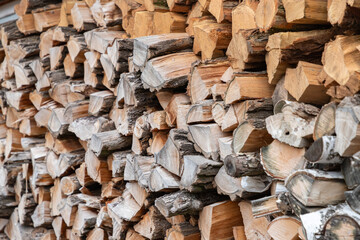 Stacked firewood. Preparation of firewood for the winter. Stocks of wooden firewood. Stacked firewood. Village lifestyle.