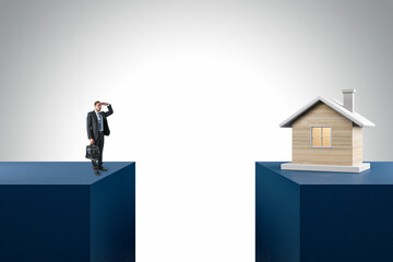 Businessman and wooden house divided by gap on light background. Mortgage and loan concept.