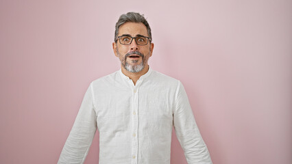 Obraz premium Oh wow! grey-haired young hispanic man with surprising expression, amazed and standing over an isolated pink background, totally incredible. handsome male with open mouth and glasses.