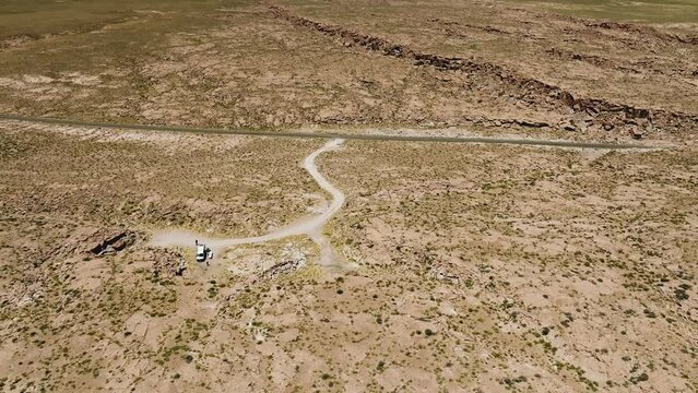 Turistas em furg&atilde;o parados no meio do deserto com apenas uma estrada &agrave; vista.