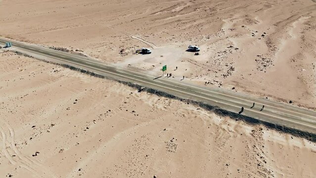 Turistas em furg&atilde;o parados no meio do deserto com apenas uma estrada &agrave; vista.