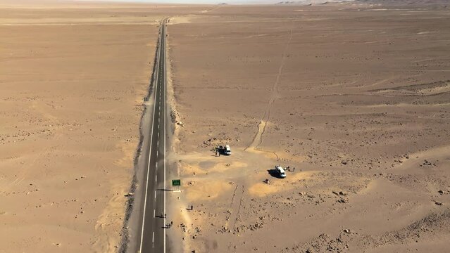 Turistas em furg&atilde;o parados no meio do deserto com apenas uma estrada &agrave; vista.