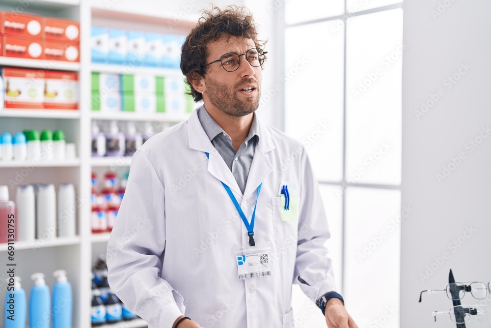 Poster Young hispanic man pharmacist speaking at pharmacy