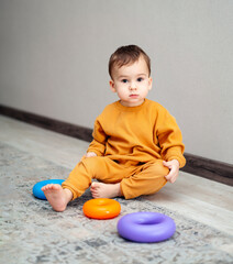 Playful small baby with colorful toys. Adorable game activity.