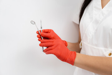 Tooth healthcare instruments. Dentistry gloved hands holding tools. - obrazy, fototapety, plakaty