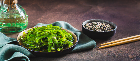 Traditional fresh seaweed and sesame salad on a plate on the table web banner