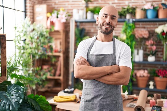 Young bald man florist smiling confident standing with arms crossed gesture at florist