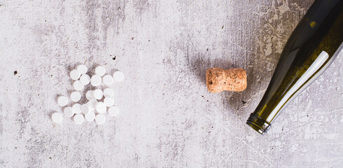 Sobriety concept, alcoholism pills, empty bottle and cork on table top view web banner
