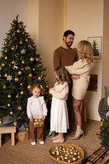 happy family near nicely decorated Christmas tree at home, enjoying the Christmas holidays.