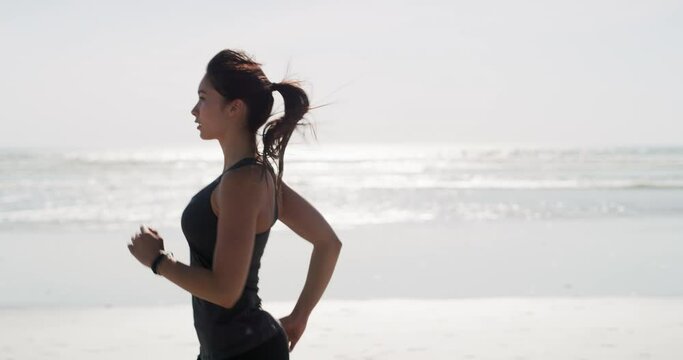 Woman, running and exercise at the beach for cardio, fitness and mockup with athlete at the ocean. Marathon, training and person outdoor with health, wellness or workout at the sea in summer morning