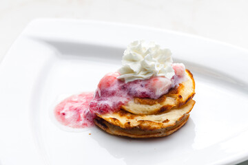 pancakes with fruit sauce and whipped cream