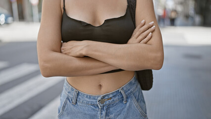 Cool and relaxed, a beautiful young hispanic woman makes a statement standing on a sunny city...
