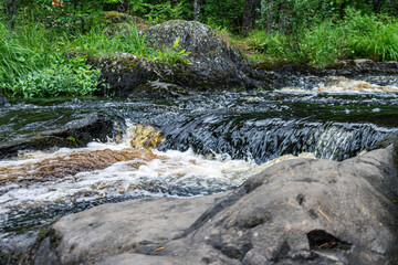 a bubbling fast cold river with cliffs and waterfalls, a mountain river with rapids