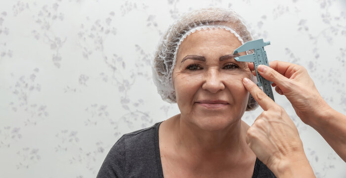 A micropigmentation technician measures the eyebrows with a ruler before beginning the procedure
