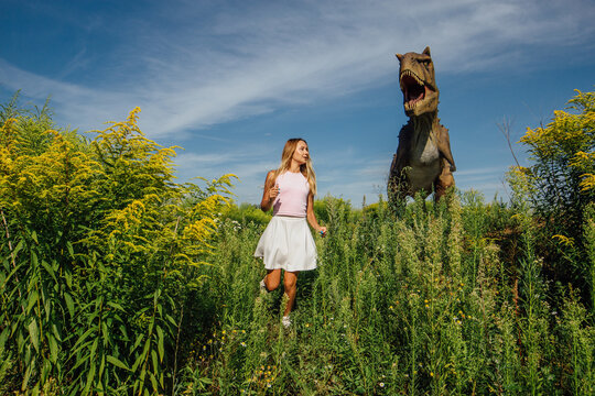 Beautiful girl running from dinosaur