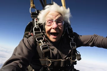 Tuinposter An elderly woman close up during a parachute jump. © Michael
