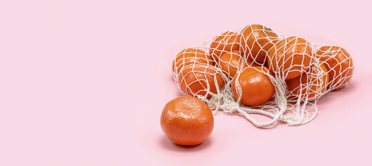 A cotton mesh bag with fresh citrus fruits. Free space for text.
