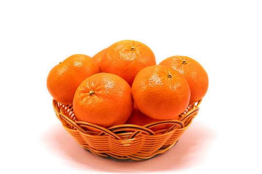 Ripe tangerine citrus, isolated tangerine orange in a wicker basket on a white background.
