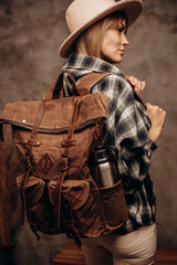 Fototapeta na wymiar Hipster woman in hat standing with hiking canvas backpack