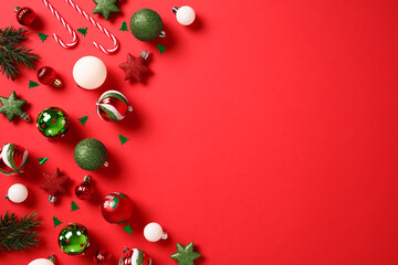 Merry Christmas and Happy New Year background with green and red balls, decorations, confetti on red background.