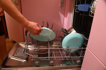 Loading dirty dishes into the dishwasher on the kitchen