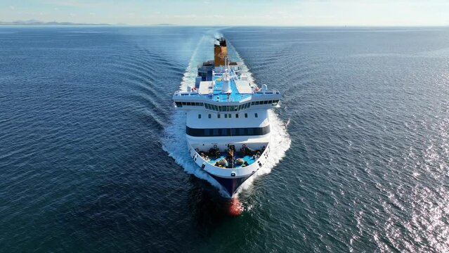 Aerial drone tracking video of passenger ferry bow cruising in high speed the Aegean deep blue sea