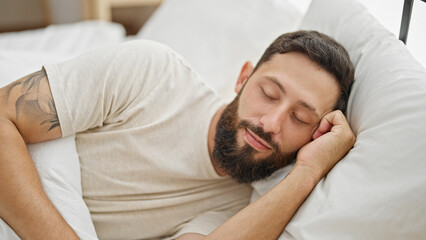 Young hispanic man lying on bed sleeping at bedroom
