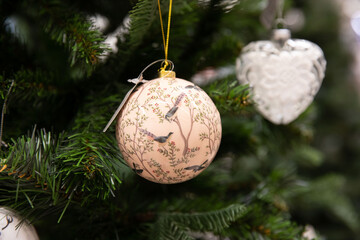 Close-up of vintage decorative ball on the branch of Christmas tree.