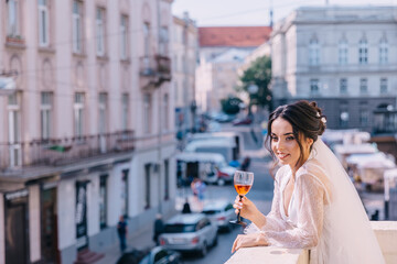 morning of the bride. A woman enjoys the view from the balcony of her room, drinks a drink in anticipation of the holidays.