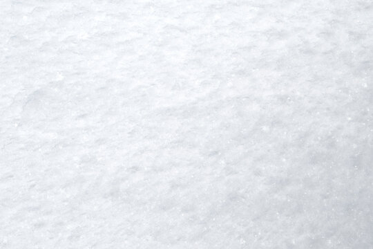 Close-up of fresh and bright snowy land in the winter, viewed from above. Abstract full frame textured background in black and white with copy space. Top view.