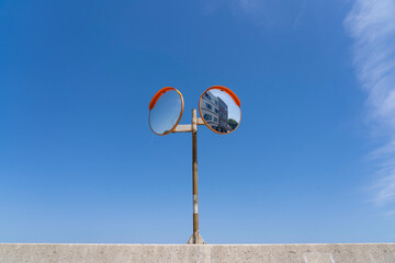 堤防の上に設置されたカーブミラーと青空