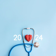 Blue stethoscope, polydiagonal decorative heart and numbers 2024 on pastel background. Medical...