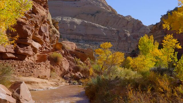 Establishing shot of mountain trail with red rocks background in Hickman Natural Bridge Trail, Capital Reef National Park, Utah, North America. Day time on October 2023. Still camera view. ProRes 422 