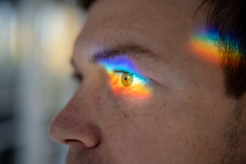 Sunlight beam falling on temple, eye, refracting through lens, creating magic optical rainbow...