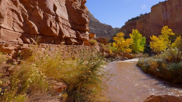 Establishing shot of mountain trail with red rocks background in Hickman Natural Bridge Trail, Capital Reef National Park, Utah, North America. Day time on October 2023. Still camera view. ProRes 422 