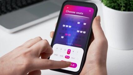 Buying cinema tickets online. Choosing seats in movie theater and buying tickets using app for mobile phone.