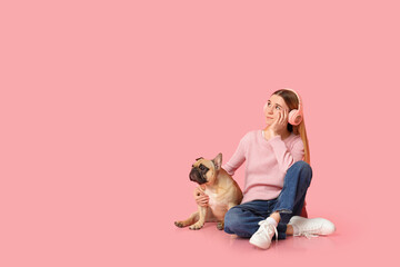 Obraz na płótnie Canvas Beautiful young woman in headphones with cute pug dog sitting on pink background